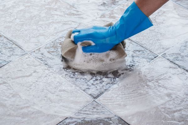 hand-man-wearing-blue-rubber-gloves-is-using-sponge-cleaning-tile-floor