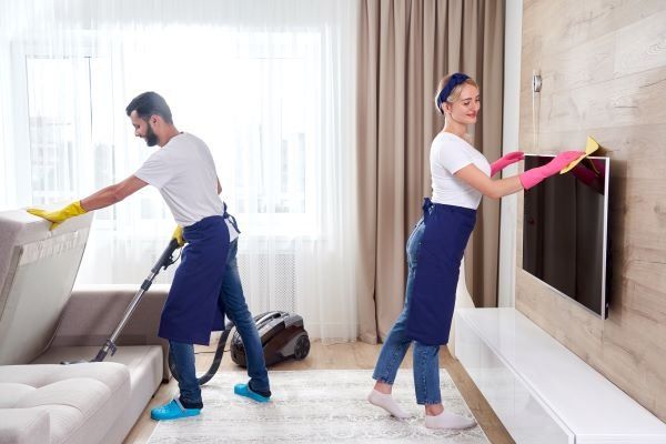 professional-cleaners-blue-uniform-washing-floor-wiping-dust-from-furniture-living-room-apartment-cleaning-service-concept