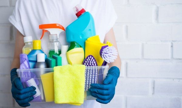 someone-is-holding-drawer-full-detergents-disinfectants-brushes-rags