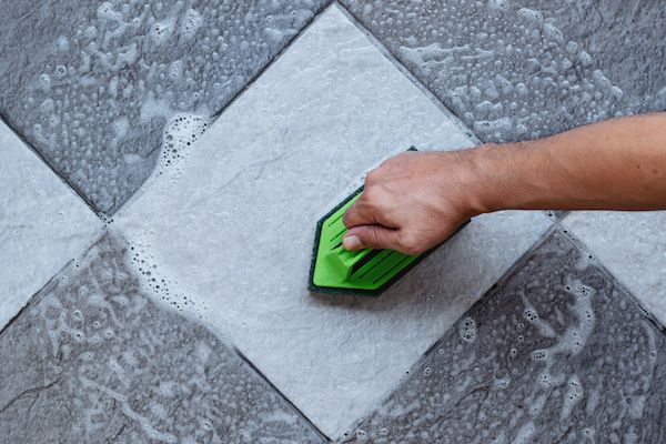 top-view-human-hand-are-using-green-color-plastic-floor-scrubber-scrub-tile-floor-with-floor-cleaner (1)
