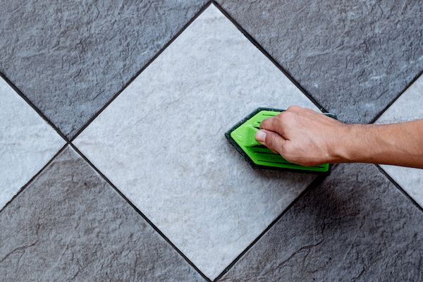 top-view-human-hand-are-using-green-color-plastic-floor-scrubber-scrub-tile-floor-with-floor-cleaner